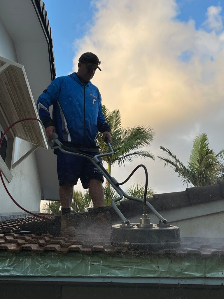 The dangers of DIY pressure washing  - man on roof with soft wash tool