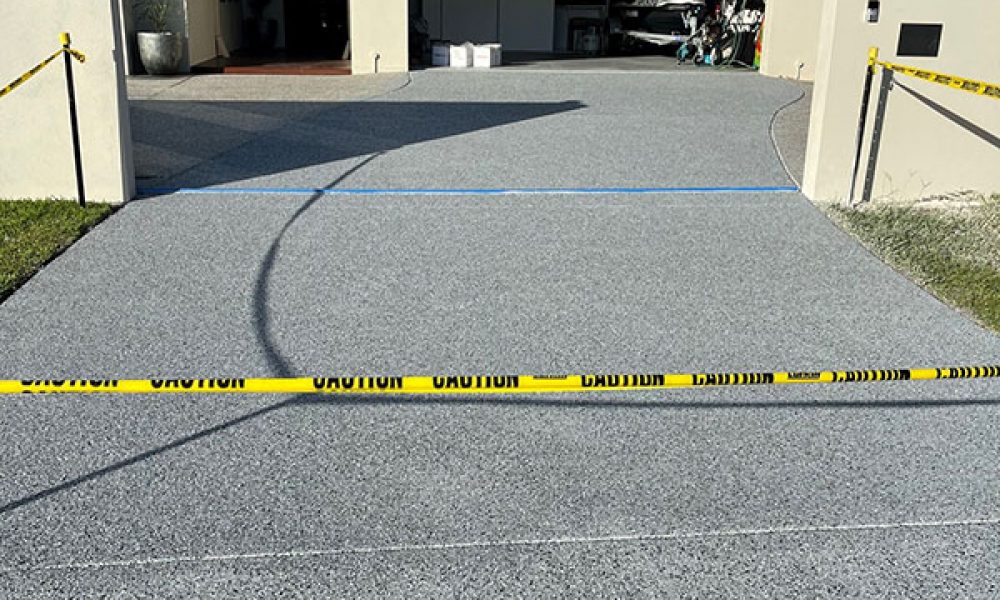 Water Attack Pressure Washing – Side view of concrete sealer drying process concrete driveway sealer - side view of residential home
